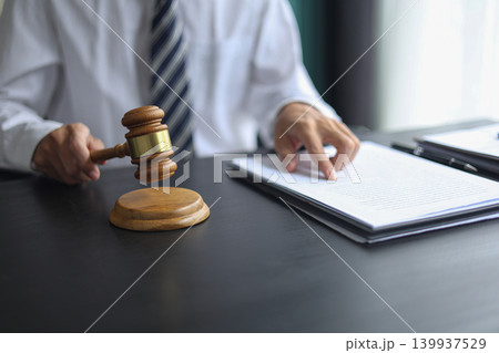 Lawyer Reviewing Contract and Documents with Gavel on Desk. Lawyer Reviewing Contract and Documents with Gavel on Desk. 139937529