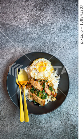 Rice topped with crispy pork belly with Thai basil and fried egg 139941207