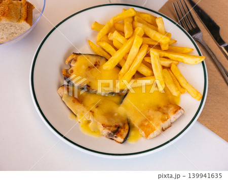 Roast swordfish in hollandaise sauce with fried potatoes Roast swordfish in hollandaise sauce with fried potatoes 139941635