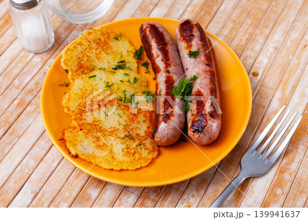 Ukrainian deruny, potato flapjacks, with fried sausages on plate 139941637