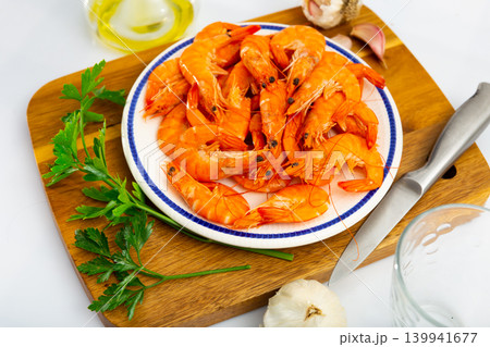 Delicious roasted prawns served with garlic and parsley on wooden cutting board 139941677