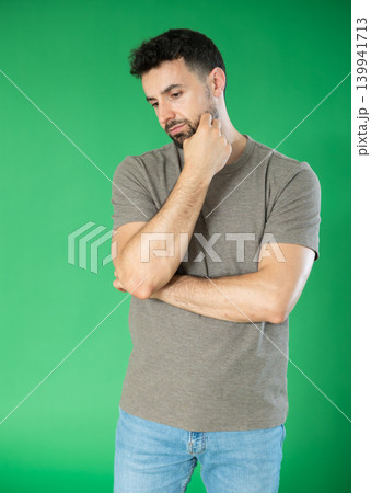 Adult man sad and upset in front of green screen 139941713