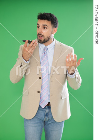 Adult man emotionally records an audio message on a mobile phone. Chroma key compositing 139941721