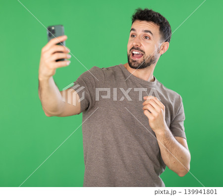 Adult man taking selfie in front of green screen 139941801