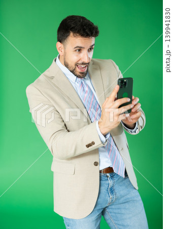 Adult man taking photo or scanning QR code in front of green screen 139941830