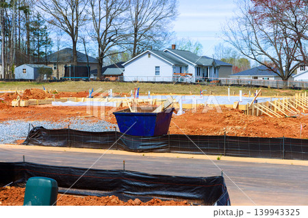 Construction is in progress at site with foundation work taking place materials set up in neighborhood. Construction is in progress at site with foundation work taking place materials set up in neighborhood. 139943325