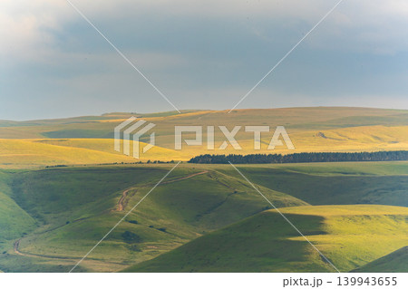 Layers of green mountains and hills in the haze during sunset. Panoramic View of Green hills and Meadow. Layers of green mountains and hills in the haze during sunset. Panoramic View of Green hills and Meadow. 139943655