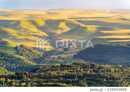 Layers of green mountains and hills in the haze during sunset. Panoramic View of Green hills and Meadow. 139943694