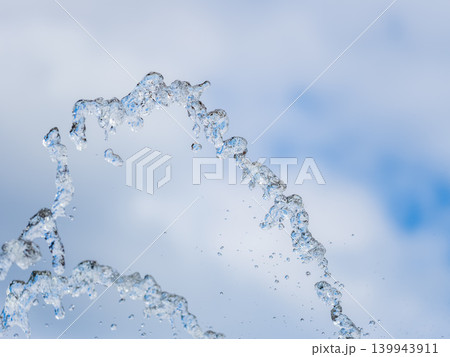 Splashes and jets of water against light background. Splashes and jets of water against light background. 139943911