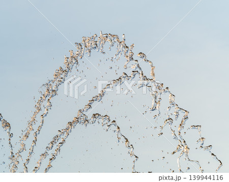 Splashes and jets of water against light background. Splashes and jets of water against light background. 139944116
