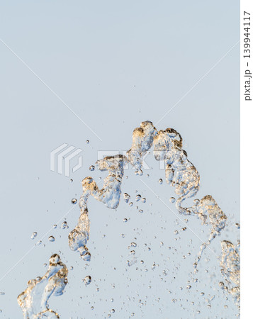 Splashes and jets of water against light background. Splashes and jets of water against light background. 139944117