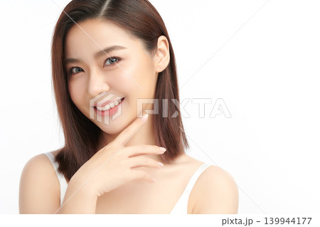 A beautiful young Asian woman with clean, fresh skin against a white background. Skincare, facial treatment, cosmetology, beauty, and spa. An elegant portrait of an Asian woman. A beautiful young Asian woman with clean, fresh skin against a white background. Skincare, facial treatment, cosmetology, beauty, and spa. An elegant portrait of an Asian woman. 139944177