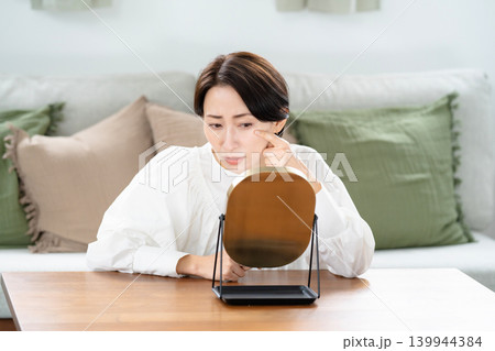鏡で肌をチェックする女性 鏡で肌をチェックする女性 139944384