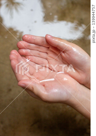 水をすくう子どもの手 縦位置 139944757