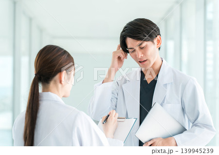 同僚,後輩と会話する白衣を着た医者,研究員(考える,困る,悩む,トラブル) 同僚,後輩と会話する白衣を着た医者,研究員(考える,困る,悩む,トラブル) 139945239