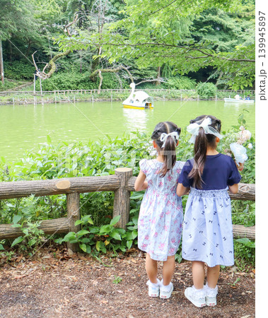 夏の公園でピクニックを楽しむ姉妹の後ろ姿 夏の公園でピクニックを楽しむ姉妹の後ろ姿 139945897
