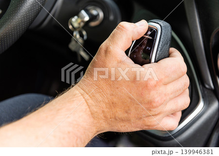 Man holding automatic gear lever in car photo Man holding automatic gear lever in car photo 139946381