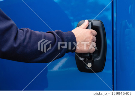 Man opening blue commercial vehicle door photo Man opening blue commercial vehicle door photo 139946405