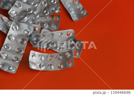 Close-up of used empty blister packs from pills on a bright red background. 139946696