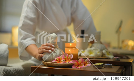 Spa setup with herbal compress candles flowers and relaxing wellness mood 139947201