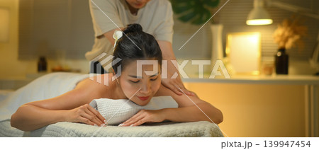 Therapist giving professional deep tissue massage on woman back. Wellness concept Therapist giving professional deep tissue massage on woman back. Wellness concept 139947454