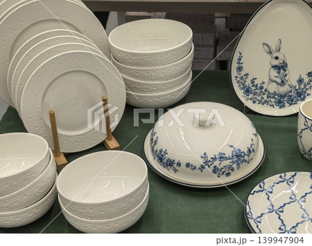 White and blue ceramic dinnerware set with Easter bunny plate on green cloth White and blue ceramic dinnerware set with Easter bunny plate on green cloth 139947904