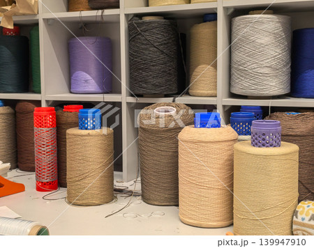 Industrial yarn cones and thread bobbins in textile workshop 139947910