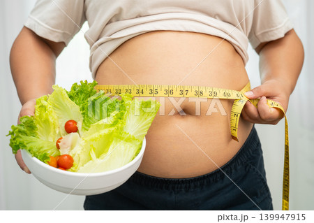 Asian woman with fat belly big size overweight and obesity with healthy food. 139947915