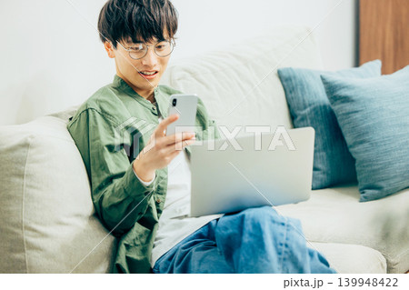 リビングでスマホを使う男性 リビングでスマホを使う男性 139948422