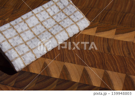 It is a cutting board and a dishcloth. It is a cutting board and a dishcloth. 139948803