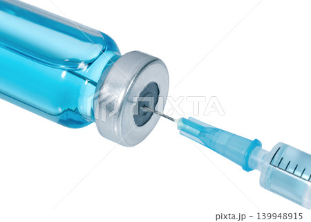 Medical syringe with the needle in the vial with blue vaccine isolated on white background. The needle speared into the vial with blue liquid. Medical syringe with the needle in the vial with blue vaccine isolated on white background. The needle speared into the vial with blue liquid. 139948915