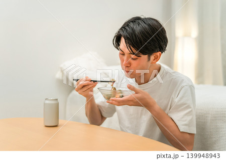 家でつまみとお酒で晩酌する若いアジア人男性（ビール,家飲み,飲酒習慣） 139948943