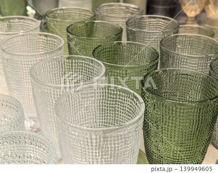 Modern textured glass tumblers in green and clear colors closeup view Modern textured glass tumblers in green and clear colors closeup view 139949605