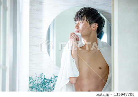 洗面所で肌をチェックする男性 洗面所で肌をチェックする男性 139949709