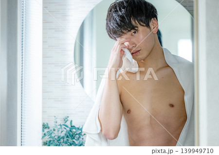 洗面所で肌をチェックする男性 139949710