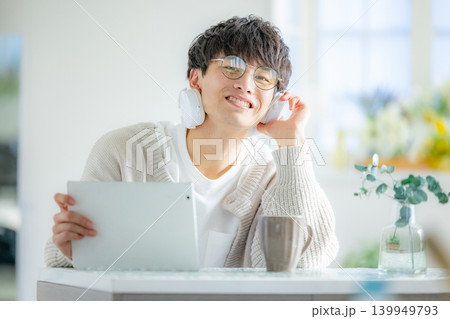 部屋でタブレットを見る眼鏡の男性 部屋でタブレットを見る眼鏡の男性 139949793