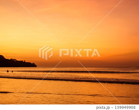 Sunset over Jimbaran Beach with silhouetted figures on shoreline, Bali, Indonesia Sunset over Jimbaran Beach with silhouetted figures on shoreline, Bali, Indonesia 139949908