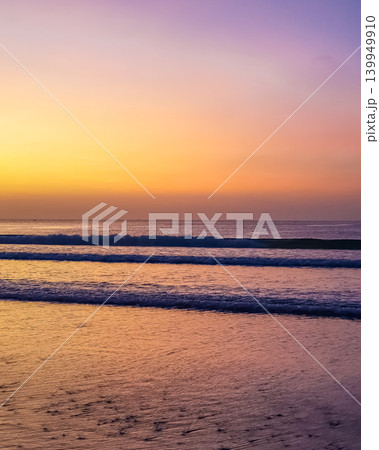 Twilight sky with yellow and purple gradient over ocean waves at Jimbaran Beach, Bali, Indonesia Twilight sky with yellow and purple gradient over ocean waves at Jimbaran Beach, Bali, Indonesia 139949910
