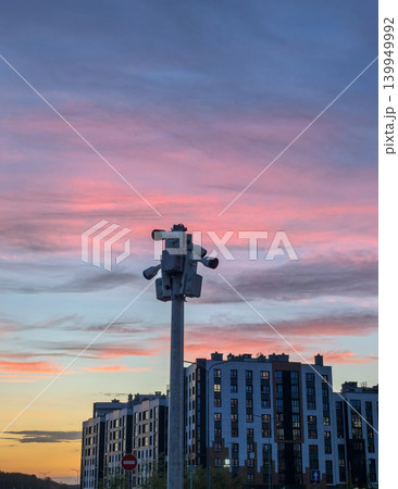 Surveillance cameras on pole against colorful sunset sky in residential area Surveillance cameras on pole against colorful sunset sky in residential area 139949992