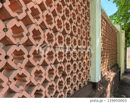Decorative red brick fence with geometric pattern and concrete pillars 139950003