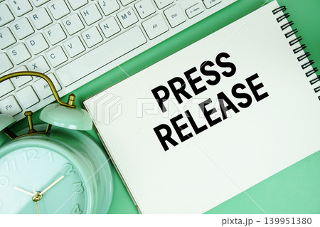 Notepad with the text "Press Release" with white keyboard and alarm clock on green background Notepad with the text "Press Release" with white keyboard and alarm clock on green background 139951380