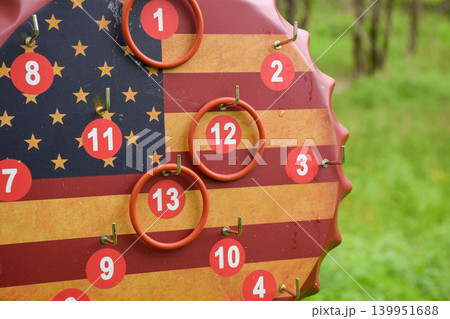 American Flag Bottle Cap Ring Toss Game Board Hanging on Tree Outdoors American Flag Bottle Cap Ring Toss Game Board Hanging on Tree Outdoors 139951688