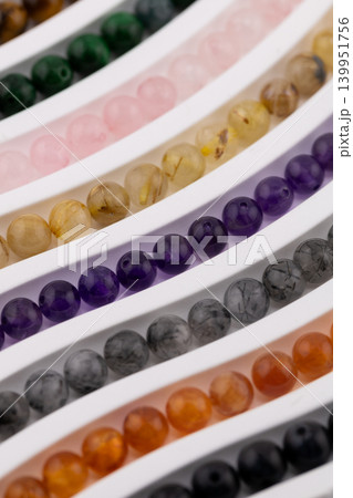 Selective focus gemstone bead strands in curved rows Selective focus gemstone bead strands in curved rows 139951756
