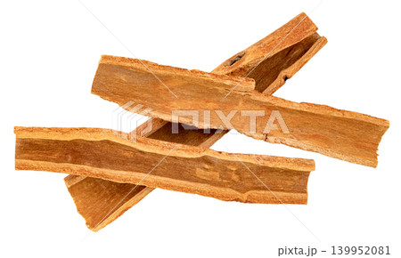 Three pieces of dried cinnamon bark isolated. Natural aromatic spice used for cooking and baking. Top view of organic cassia bark strips. High resolution macro shot. 139952081