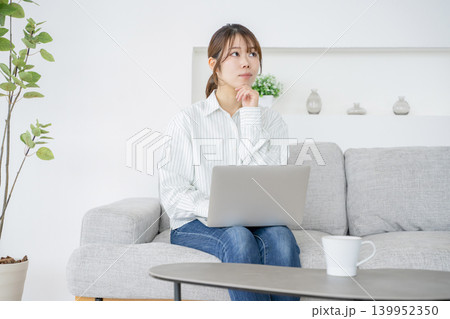 自宅でパソコンを見ながら作業をする女性 自宅でパソコンを見ながら作業をする女性 139952350