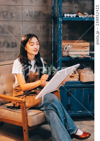Female artist wears black hat posing near picture indoor the studio Female artist wears black hat posing near picture indoor the studio 139952415