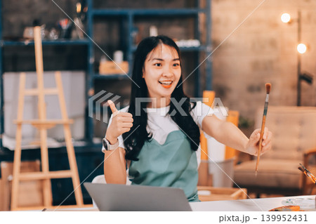 Female artist wears black hat posing near picture indoor the studio 139952431