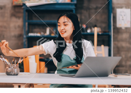 Female artist wears black hat posing near picture indoor the studio 139952432