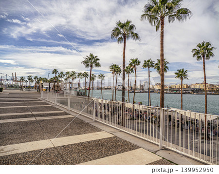 Palm-Lined Waterfront Promenade Overlooking Harbor and Malaga City Skyline With Marina and Walkway Palm-Lined Waterfront Promenade Overlooking Harbor and Malaga City Skyline With Marina and Walkway 139952950