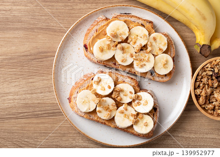 Cranberry sourdough bread with peanut butter, banana, granola and honey, Healthy homemade breakfast 139952977